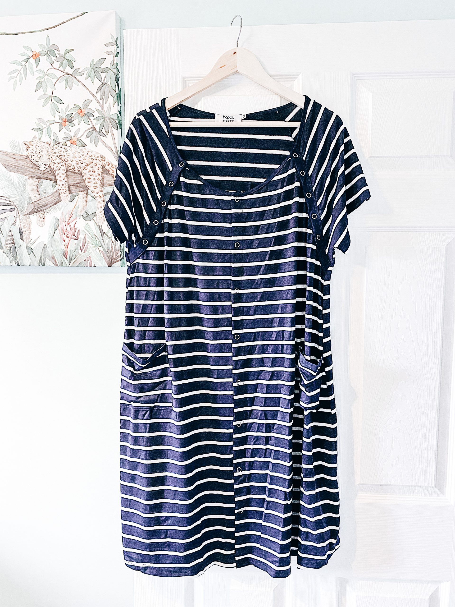 a stripy labour gown hung on a door by a coat hanger hospital bag