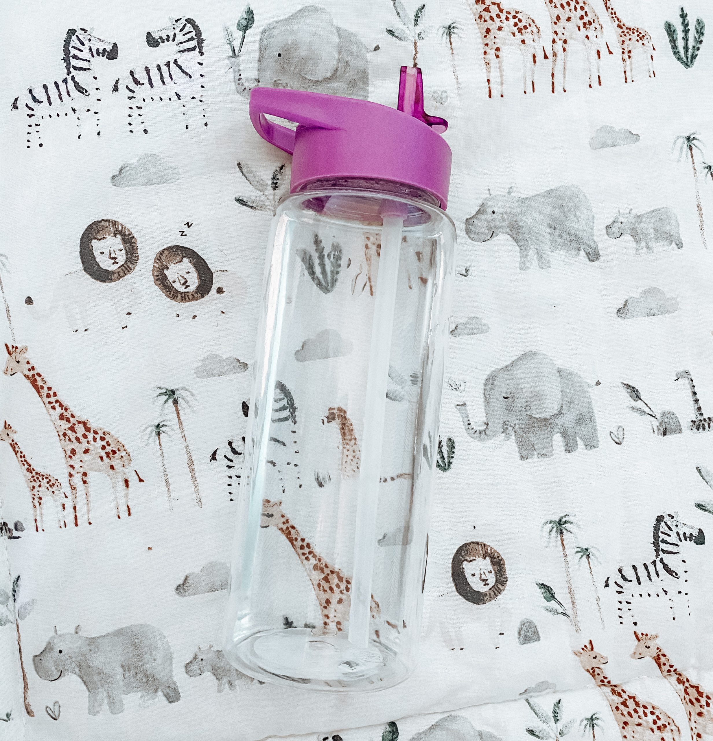 a straw water bottle on safari cot sheet