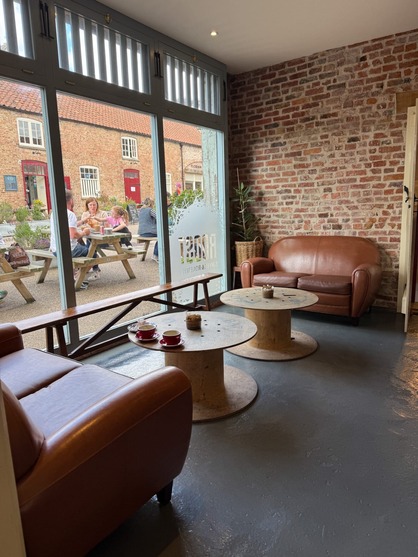 Inside the Roost Coffee espresso bar in Talbot Yard with leather sofas and the roastery equipment visible