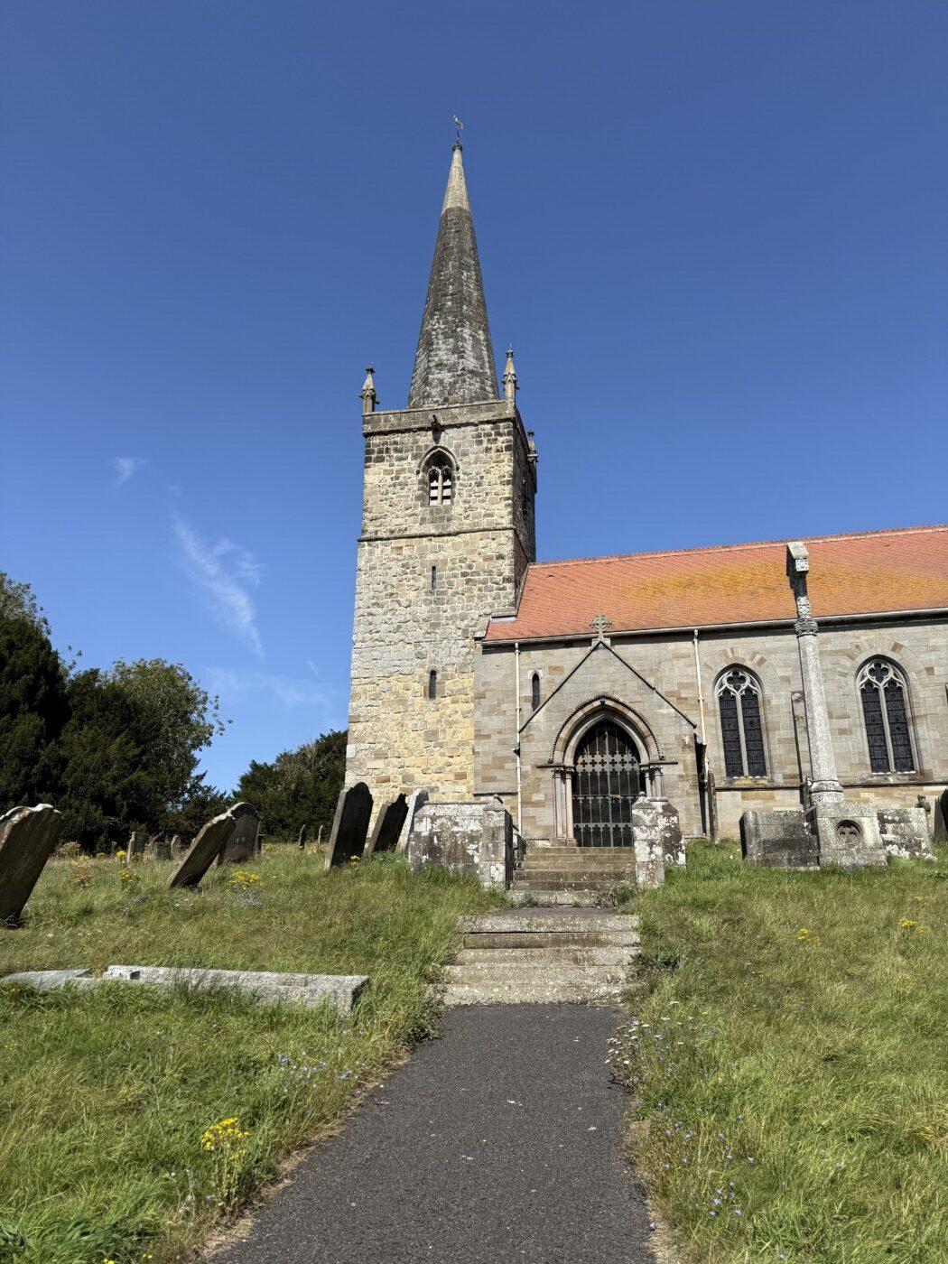 Exterior of the Grade I listed St Andrew's Church in Kirby Grindalythe showing the Norman tower