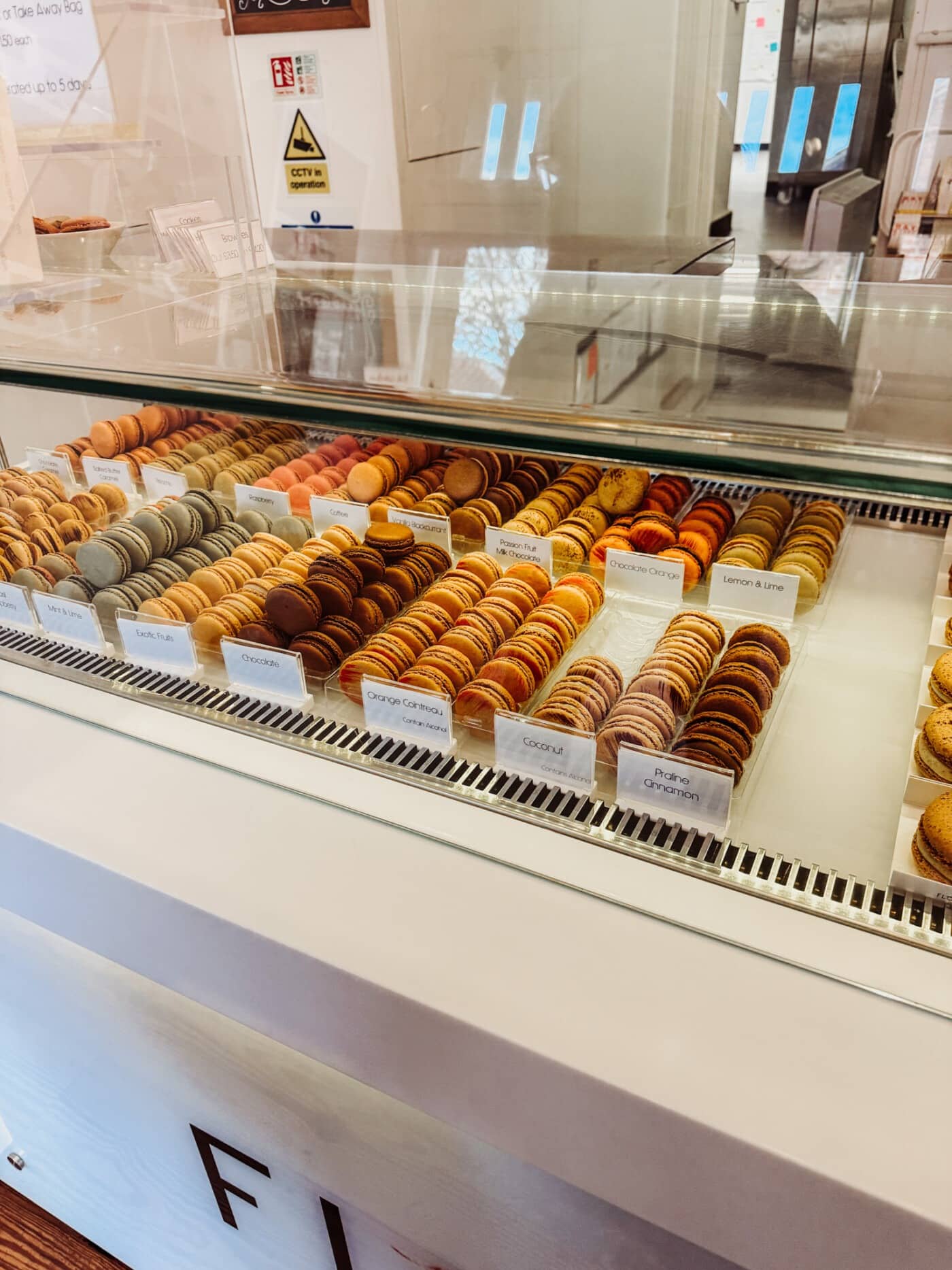 Display counter at Florian Poirot Malton showing rows of colourful French macarons