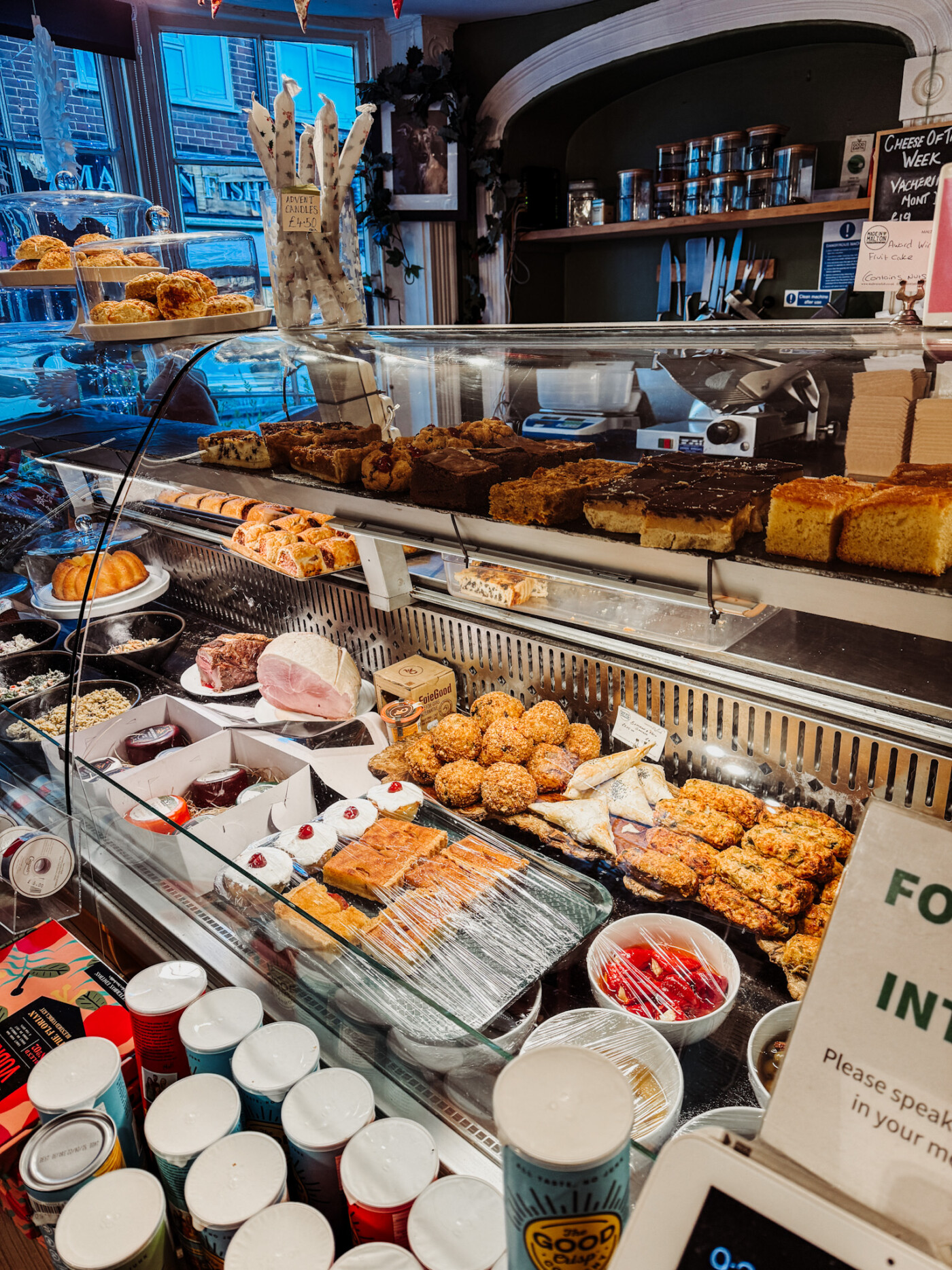 Deli counter at Malton Relish showing Yorkshire cheeses, sausage rolls and pork pies for sale
