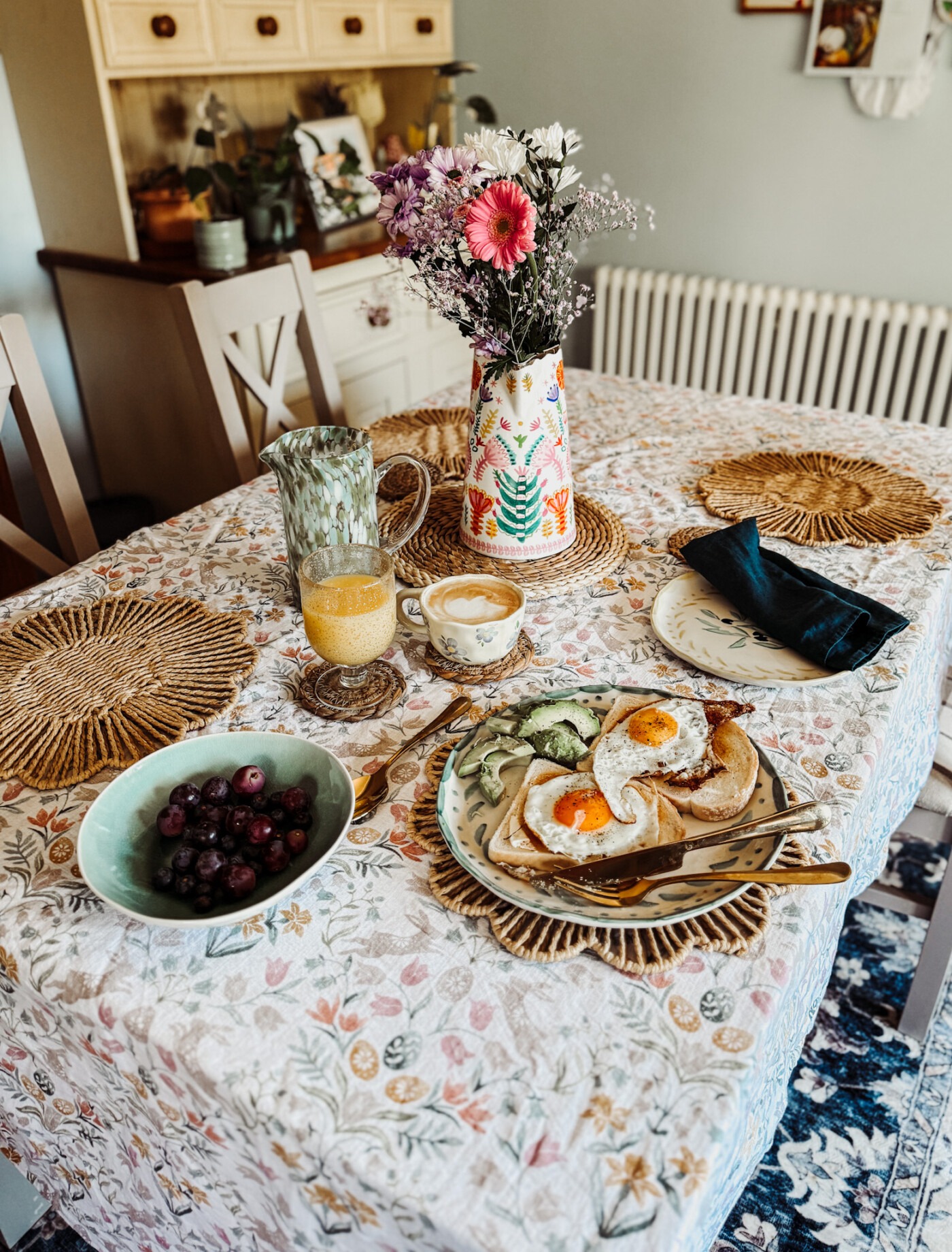Spring breakfast table flatlay with eggs on toast, avocado, orange juice and coffee
