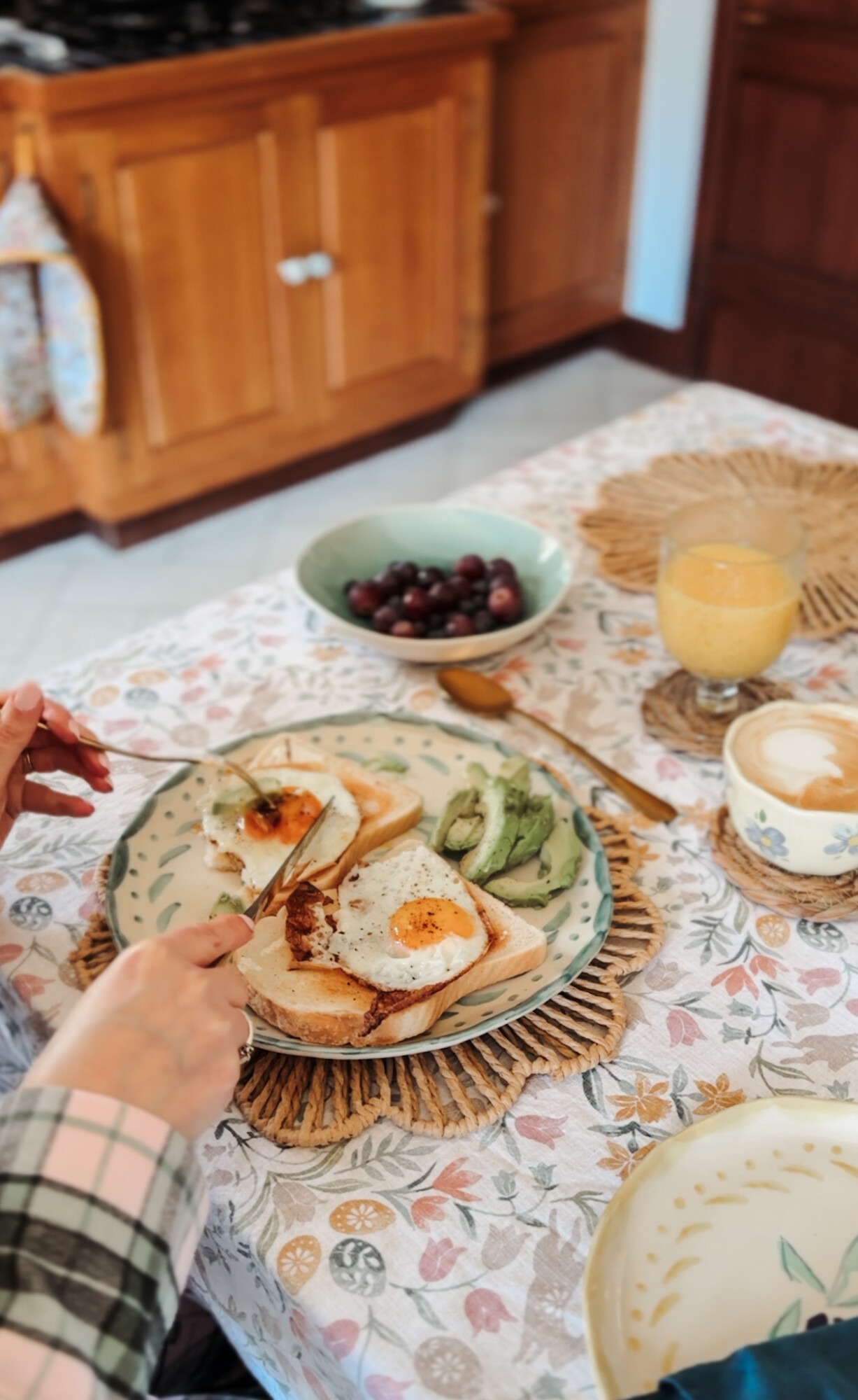 Cutting into eggs on toast at a spring breakfast table wearing British Boxers Burnet Rose Tartan pyjamas