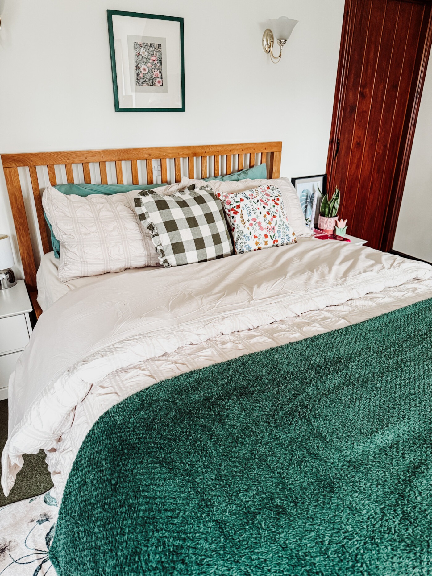 Close-up of textured beige seersucker duvet cover with green throw blanket showing fabric detail and layered spring bedding styling