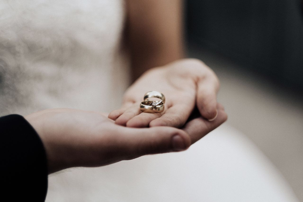 Bride holding wedding bands in a tender moment, symbolizing love and commitment
